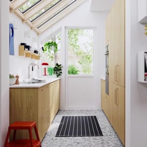 Geräumige, moderne Küche mit großen Dachfenstern und einer Türfront aus Glas.