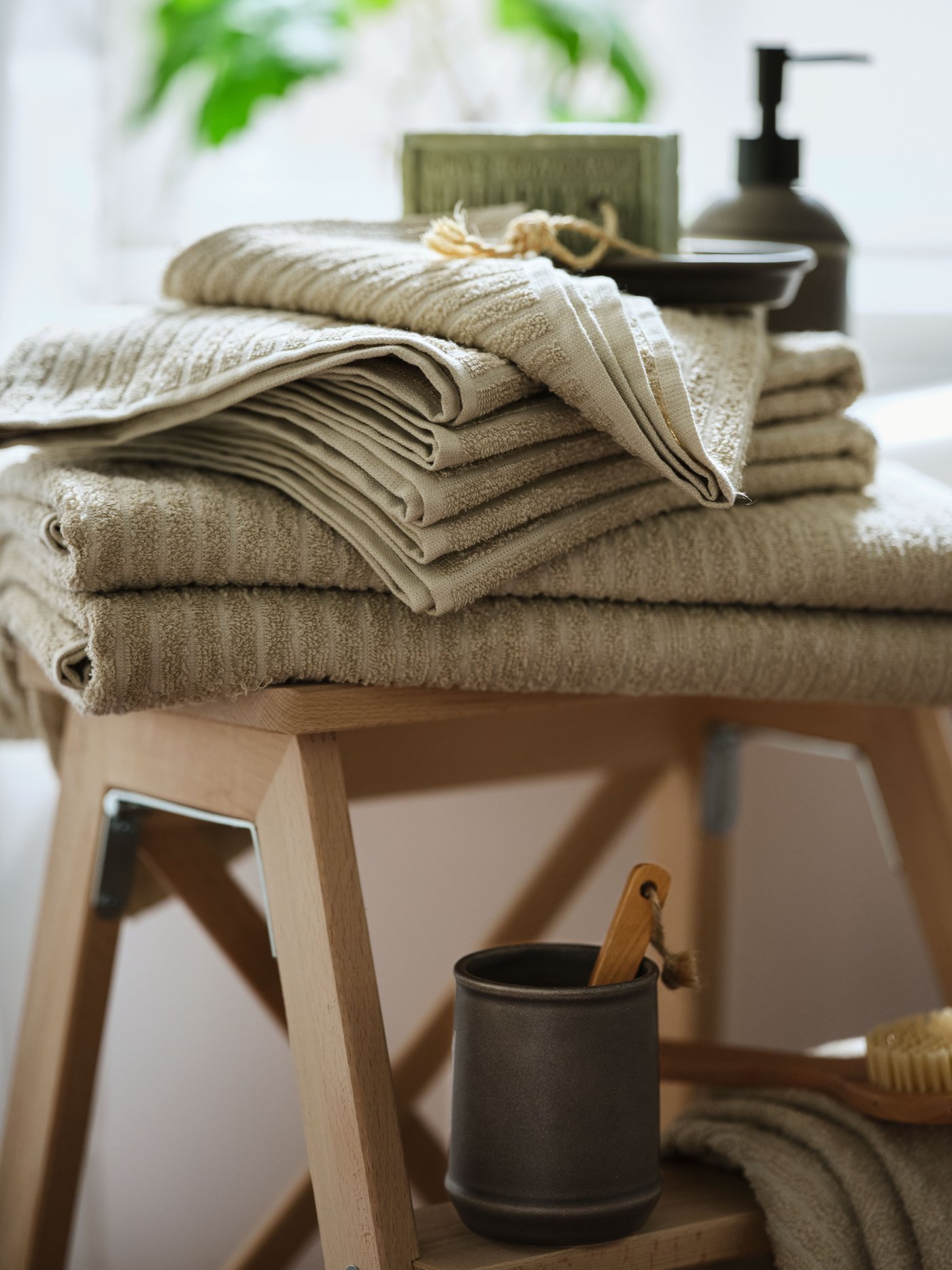 Pino vaaleanbeigejä VÅGSJÖN-pyyhkeitä puisen jakkaran päällä.