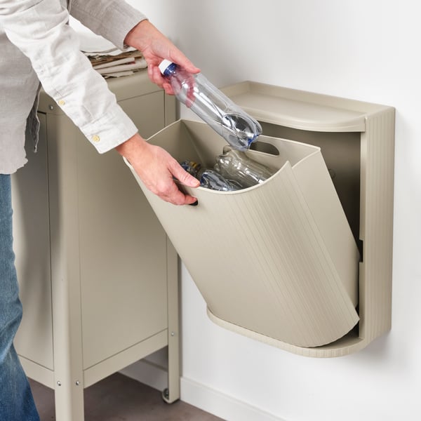Person recycling in a GÅRDSBUTIK bin 