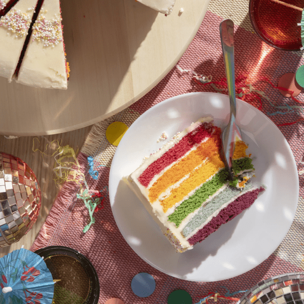 A slice of Rainbow Cake on a white plate.