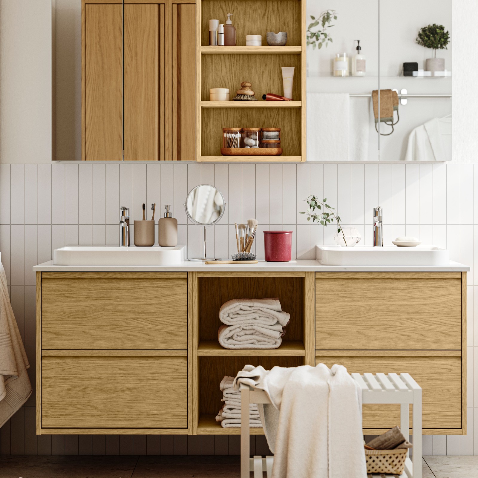 A bright bathroom has ÄNGSJÖN bathroom furniture in oak effect, including wall cabinets and a vanity with drawers.