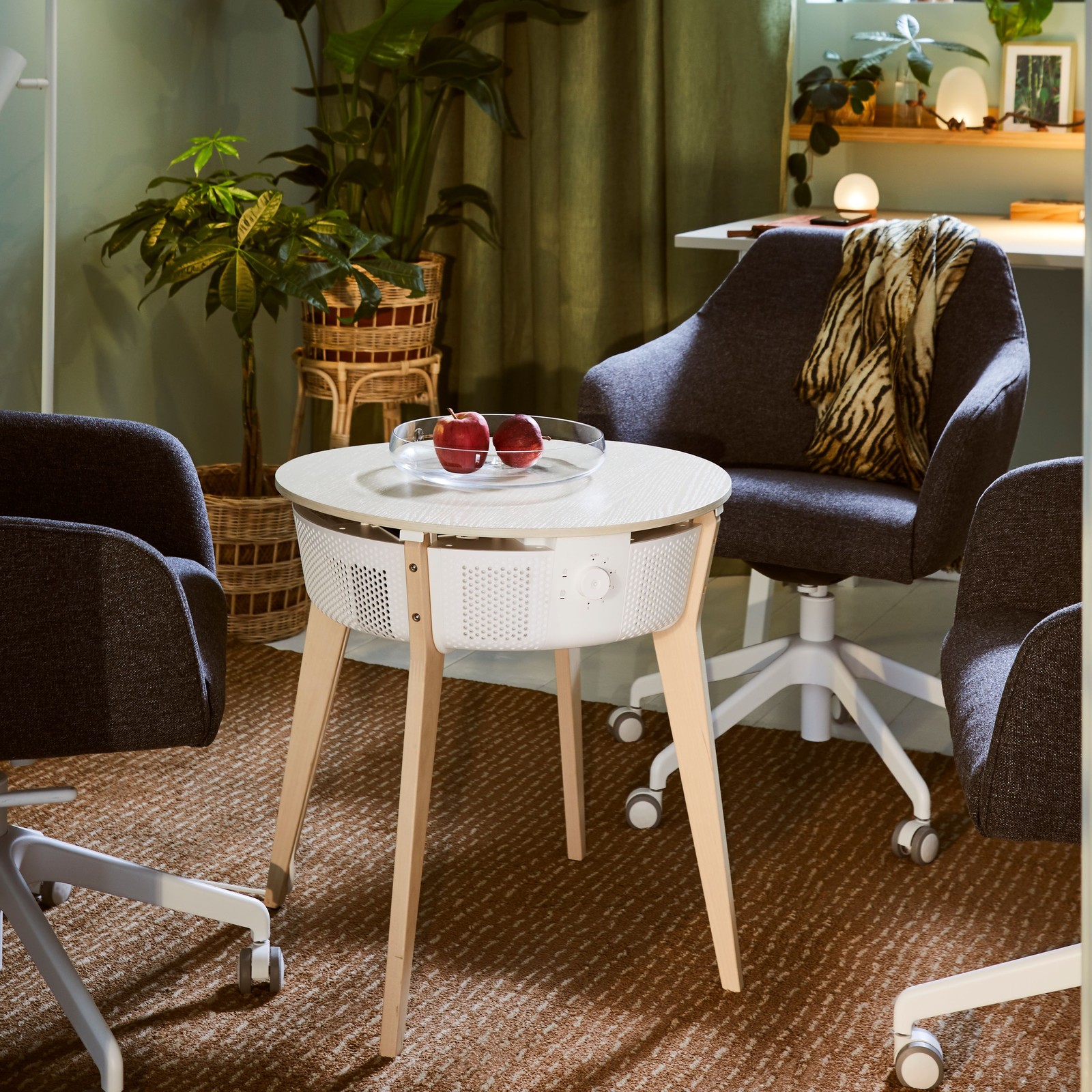 TOSSBERG konferansestoler rundt et STARKVIND bord med luftrenser i et rom med gardiner og mange planter.