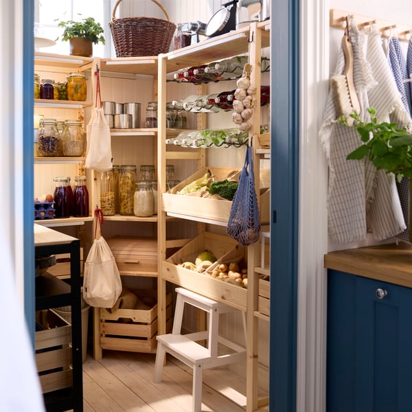 A kitchen pantry has several combinations of IVAR shelving units with food containers for storing food items.