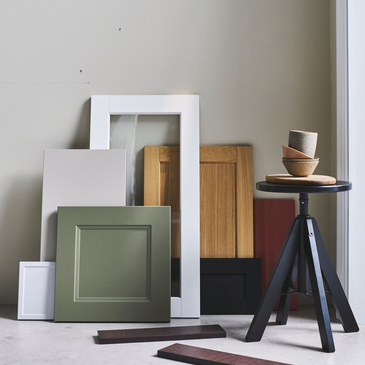 A selection of IKEA door and drawer fronts in various colours and finishes leaning up against a wall.