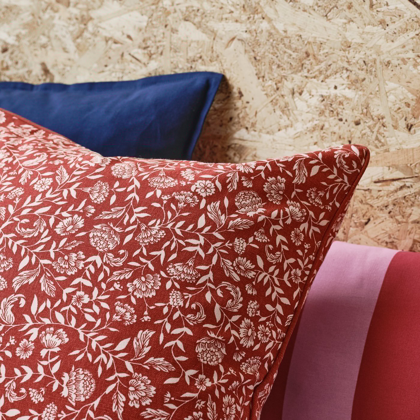 Primer pla d'un coixí EVALOUISE amb un estampat floral escandinau tradicional de color vermell i blanc.