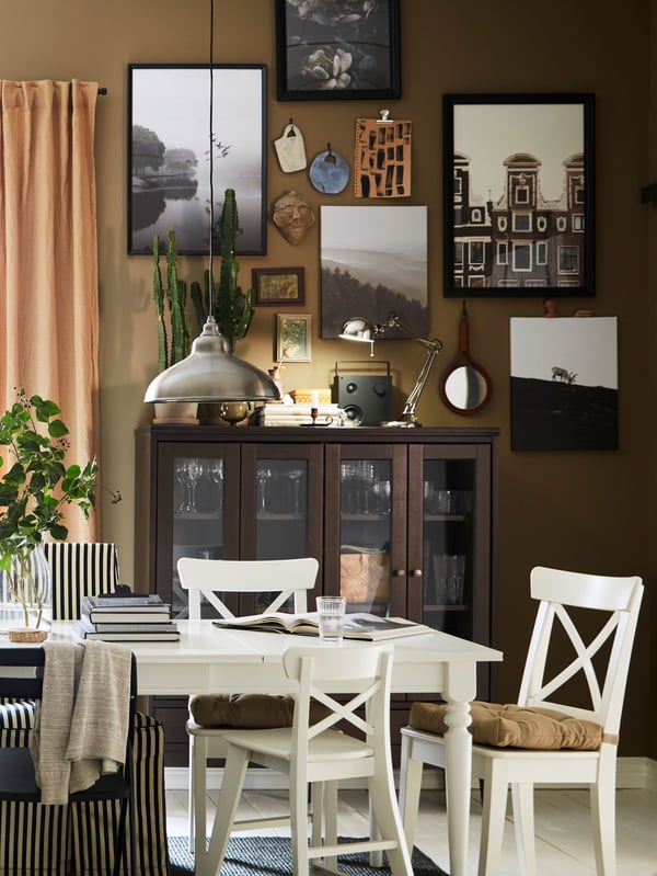 An extended INGATORP extendable table and chairs including four white INGOLF chairs stand in a traditional dining room.