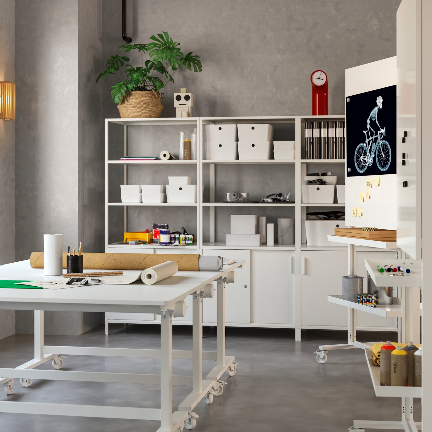 Creative workspace with two white tables on castors. Storage units with closed and open storage rest against the back wall.