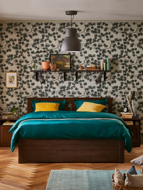 Cadre de lit SONGESAND avec du linge de lit en satin vert foncé dans une chambre avec une suspension grise.