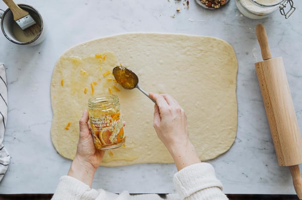 Spread with 3–4 tablespoons of orange marmalade on the dough