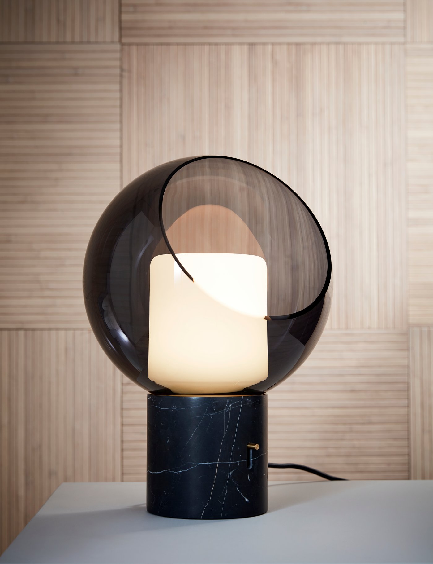 EVEDAL large organic shaped modern lamp sat on a table in front of minimal wooden panels