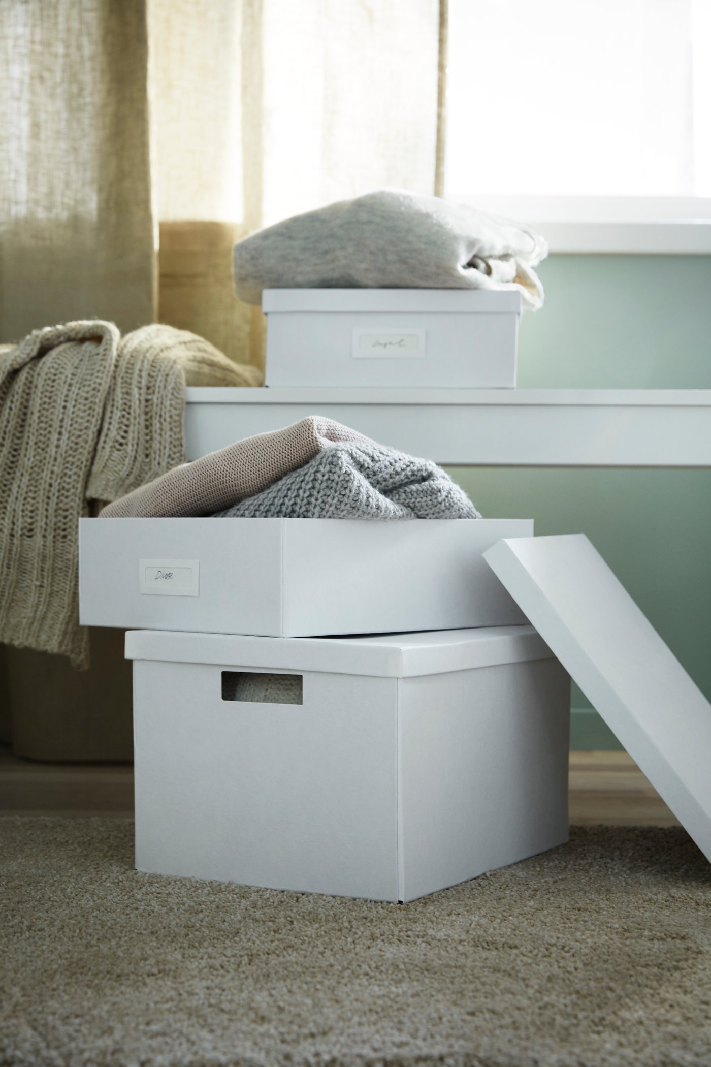 Weiße Boxen zur Aufbewahrung in verschiedenen Größen sind aufeinander gestapelt.