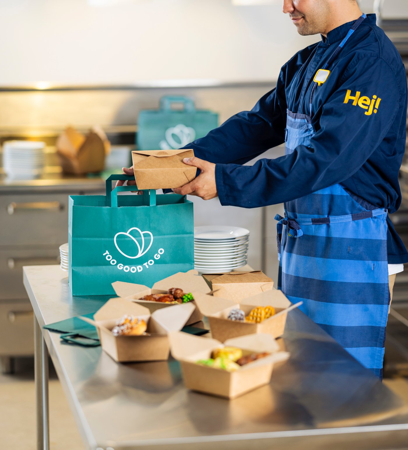 IKEA Co-worker filling Too Good to Go carrier bag with IKEA Swedish Restaurant food.