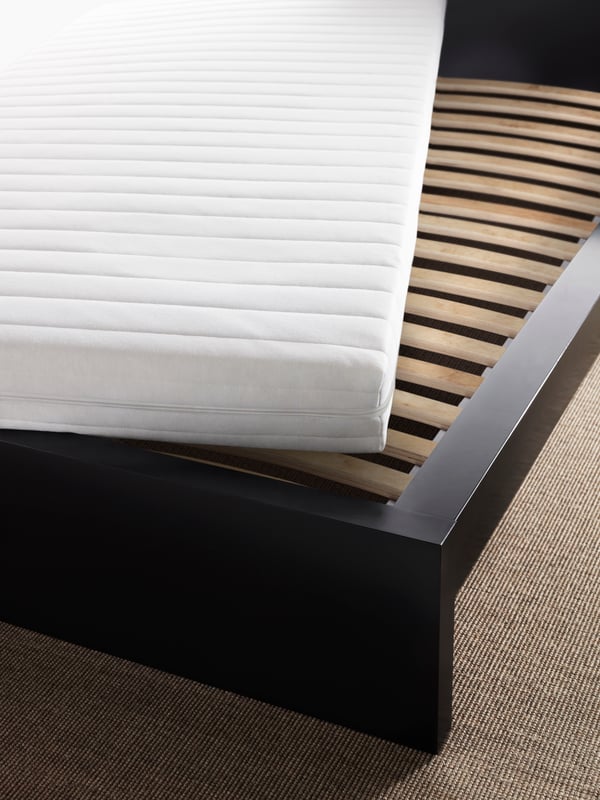 Un matelas en mousse ÅSVANG ferme/blanc dans la chambre posé sur un sommier à lattes