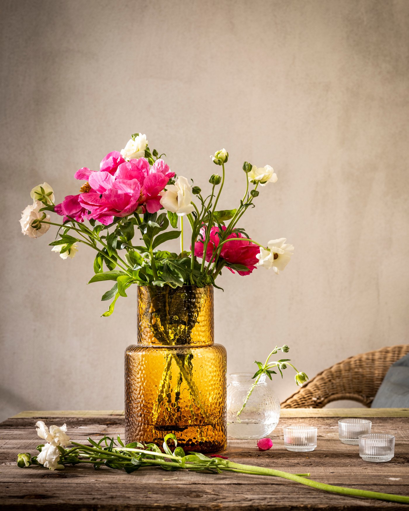 Brązowy wazon KONSTFULL ze świeżymil, różowymi kwiatami.