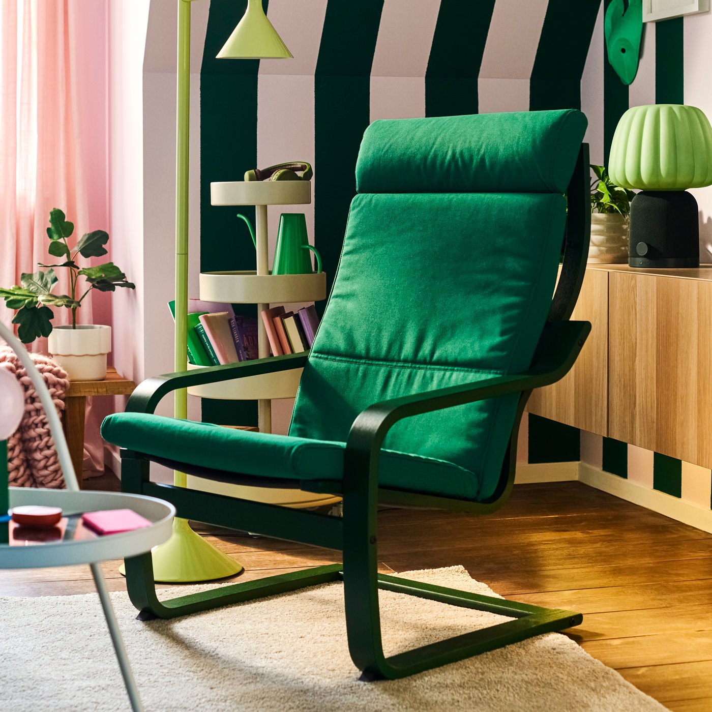 Una poltrona POÄNG verde con un cuscino verde in un soggiorno 