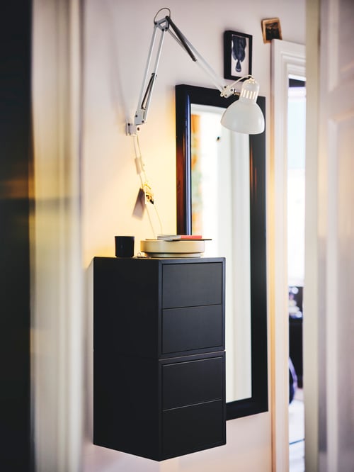 Close-up on hallway wall with tall mirror and 2 stacked dark grey wooden cabinets with two drawers mounted to the wall.