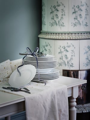 A patterned/white/gold-colour DOFTMINNE tablecloth in the dining room
