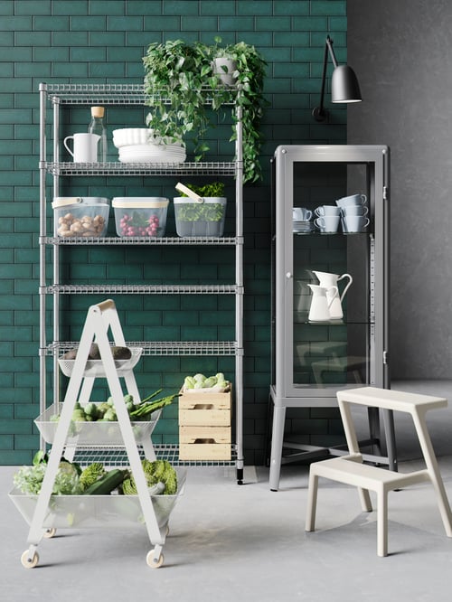 A galvanised steel OMAR one-shelf section holds serveware and mesh baskets by a glass-door cabinet, stepstool and trolley.