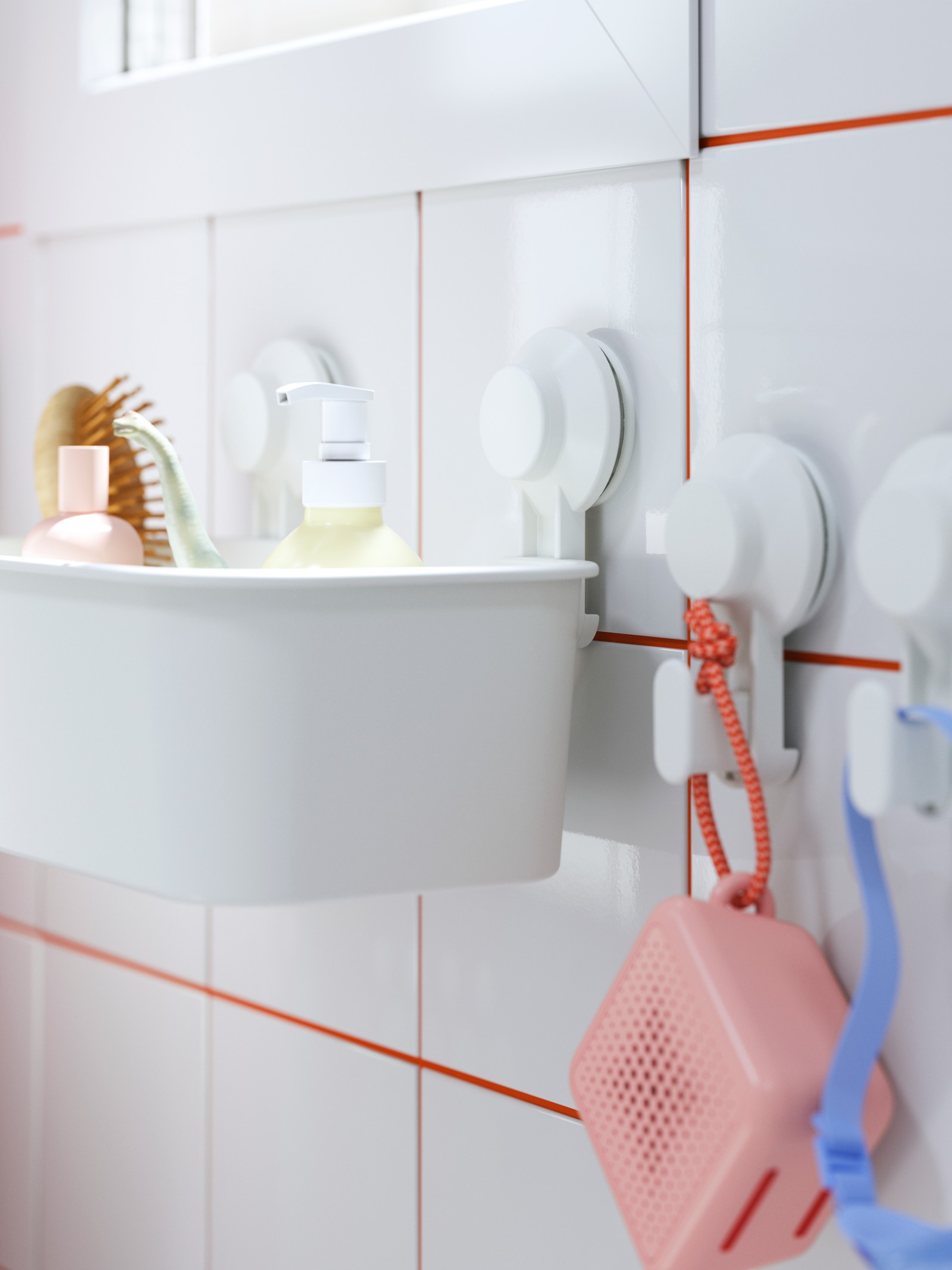A TISKEN toothbrush holder with suction cups holding toothbrushes and a hairbrush, with goggles hanging beside it.
