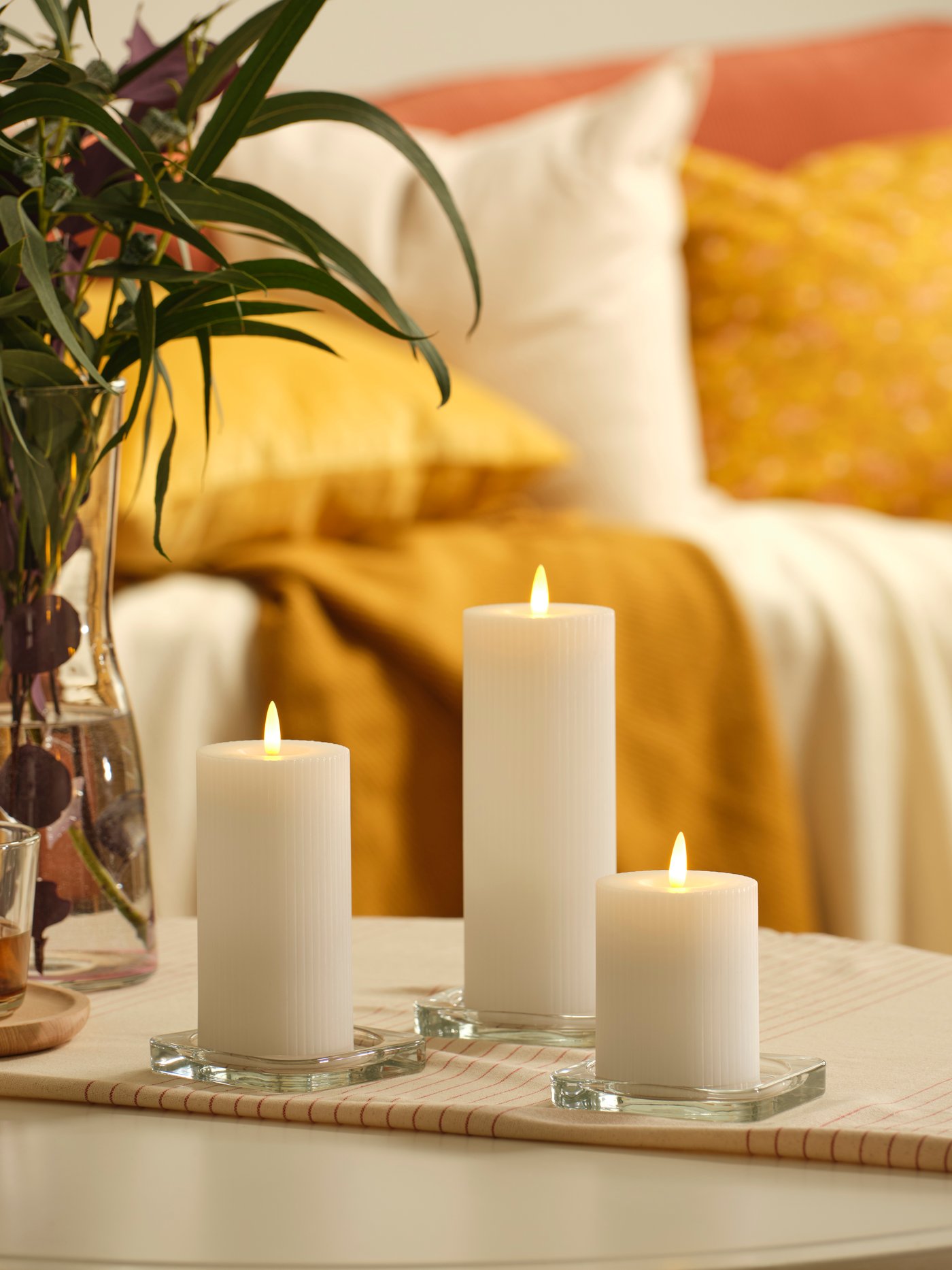 Three white block candles on the coffee table.