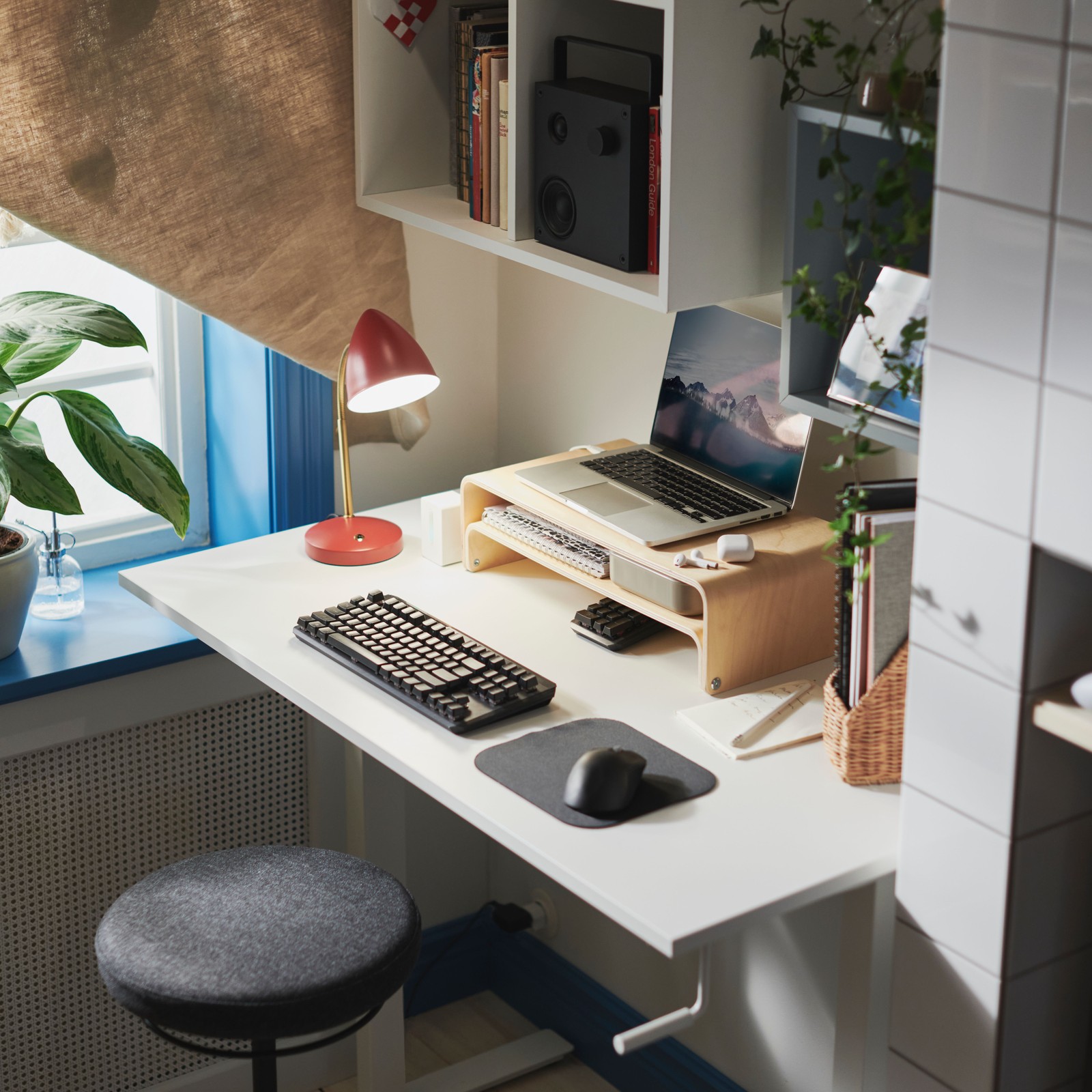 A workspace with a TROTTEN sit/stand desk with a VATTENKAR laptop/monitor stand supporting a laptop on top of it.