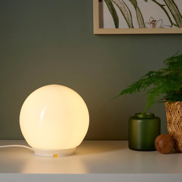 Una lámpara de mesa FADO encendida sobre una mesa.