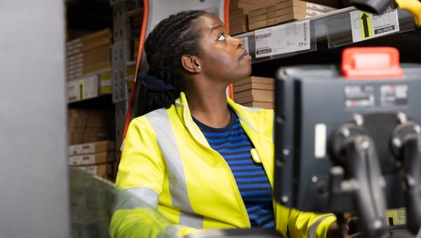 Collaboratrice IKEA, femme en logistique, dans un chariot élévateur