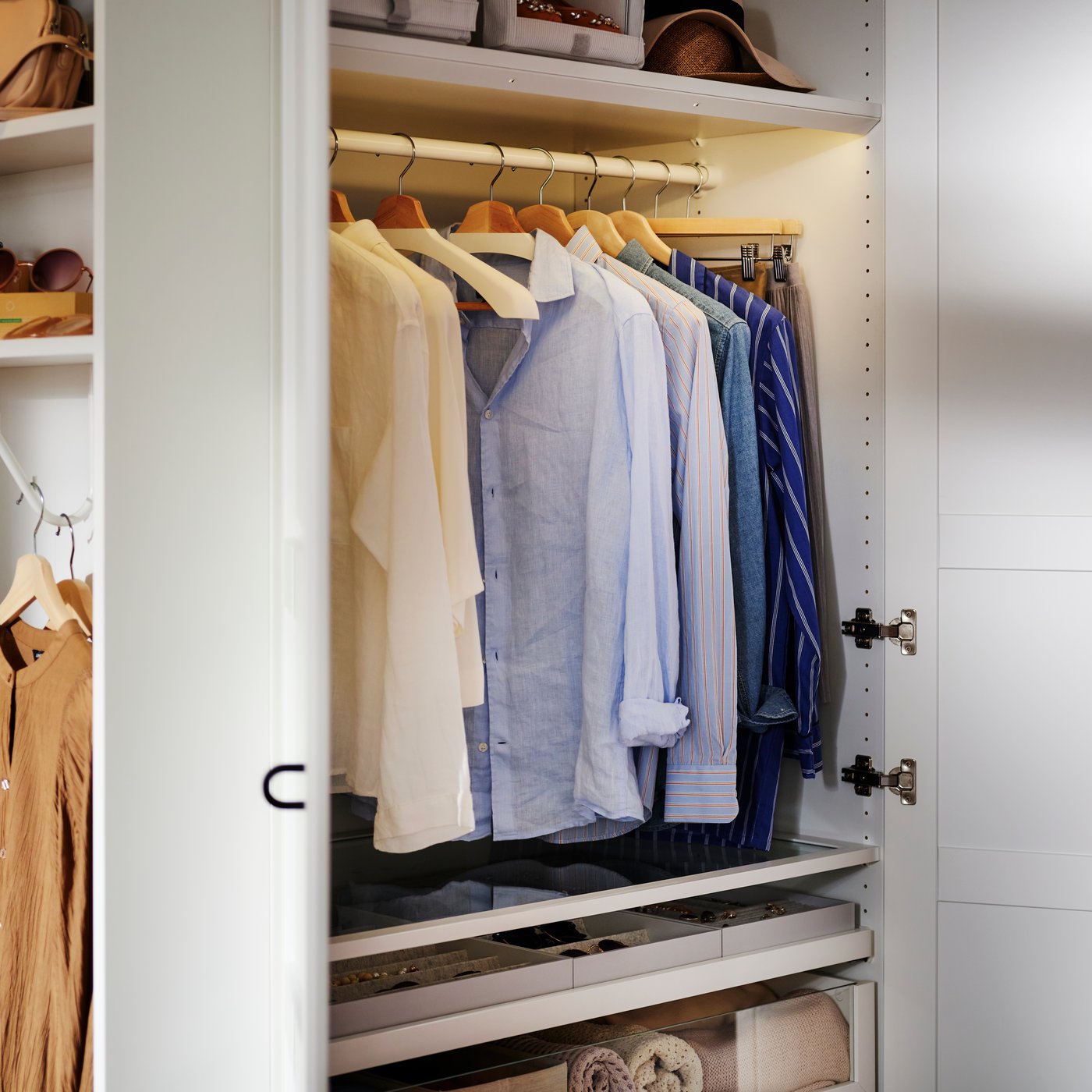 Openstaande PAX/TYSSEDAL kleerkastcombinatie met een rij hemden op BUMERANG kleerhangers met schouderverbreders die aan een kledingroede hangen.