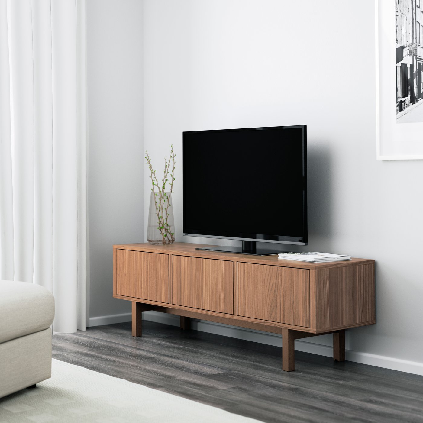 木製のイケアのテレビ台に黒いテレビが置かれた、白い壁とグレーの床のシンプルなリビング。