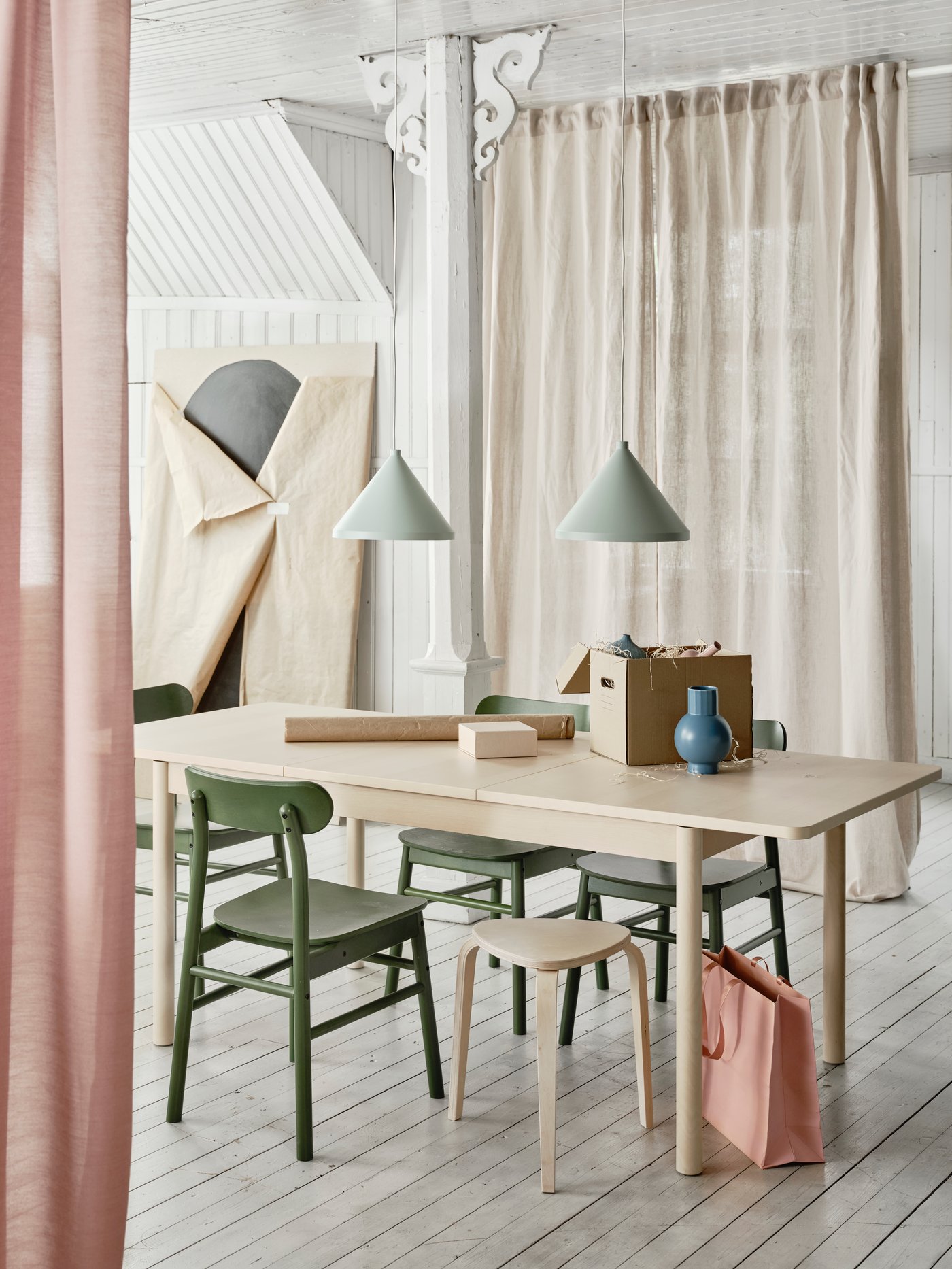 Mesa de comedor extensible RÖNNINGE color madera junto a sillas RÖNNINGE color verde.