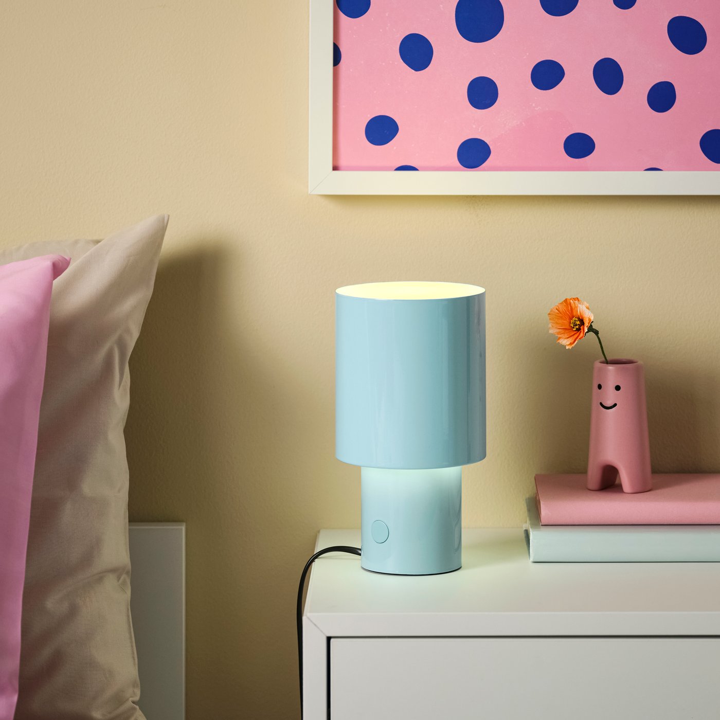 A dimmable/light blue SPETSBOJ table lamp in the bedroom