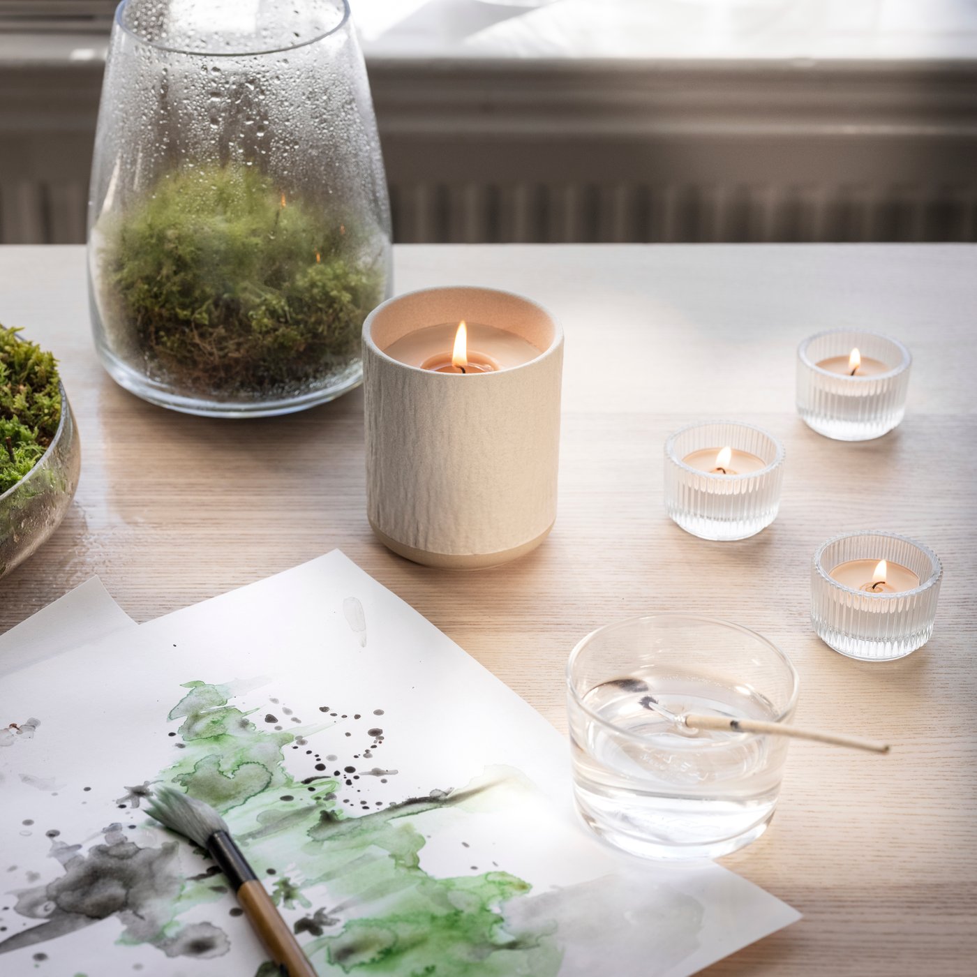 A dew & moss/off-white SILKESTRÄD scented candle in ceramic jar
