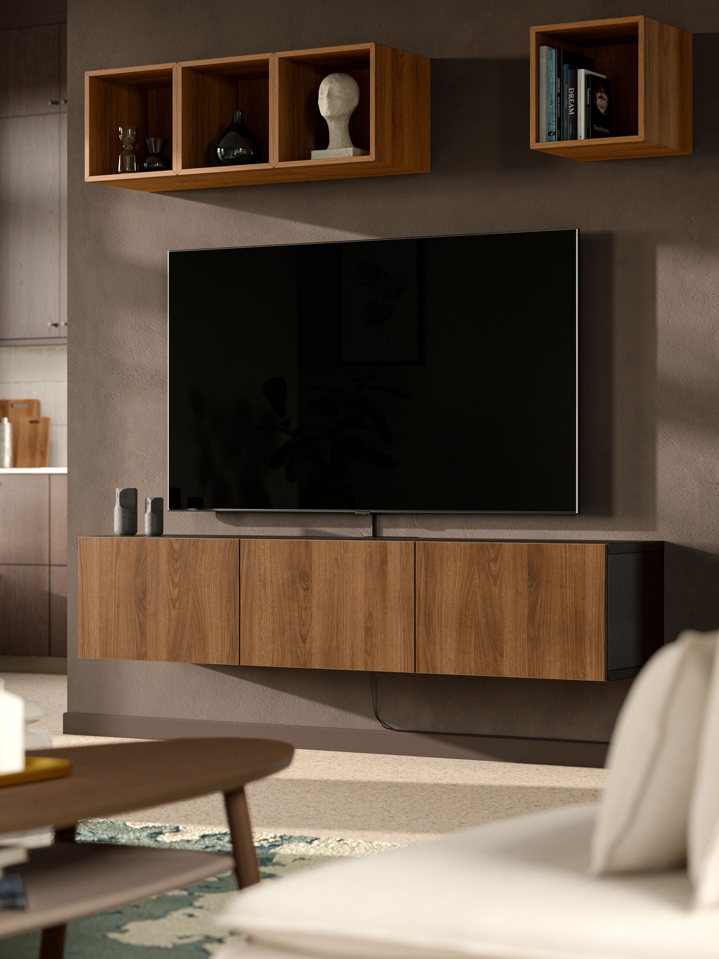 Un soggiorno con un mobile TV con ante, marrone-nero/Lappviken effetto noce BESTÅ. Sopra, una combinazione a giorno di elementi della serie EKET effetto noce.