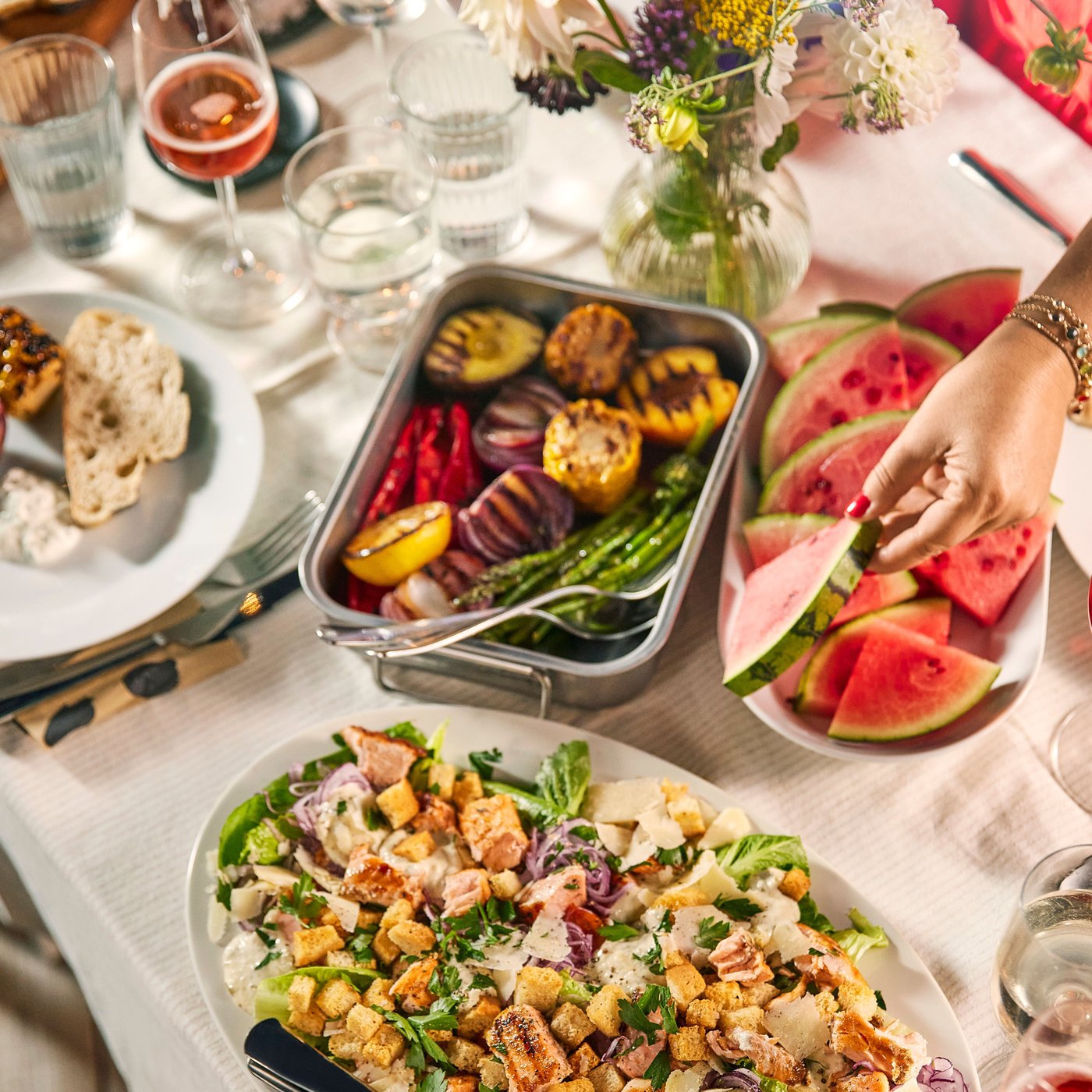 Es ist ein Tisch mit weisser Tischdecke und verschiedenen Gerichten auf Servierplatten zu sehen.