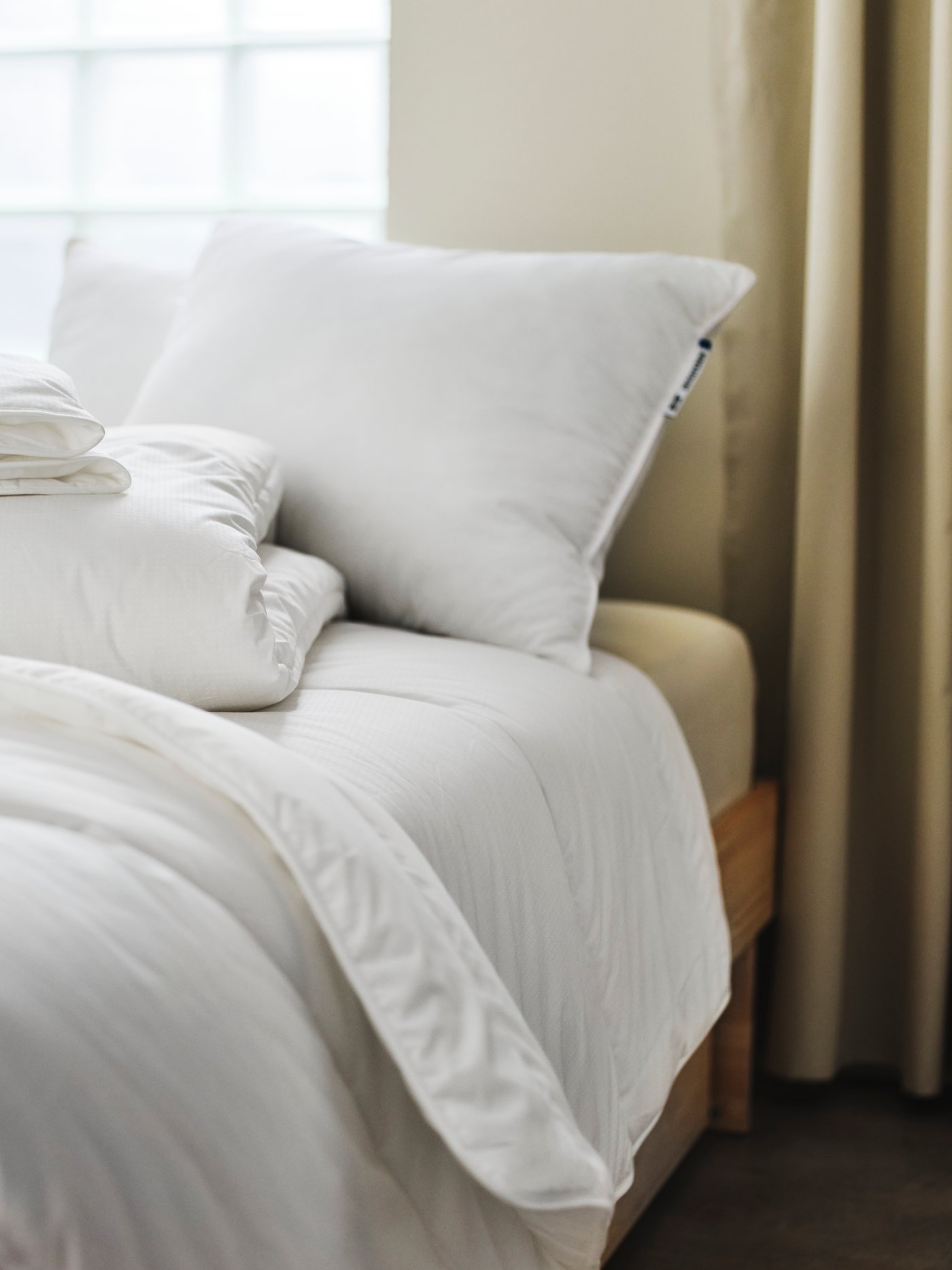 Zwei gefaltete SKOGSFRÄKEN Bettdecken liegen auf einem Bett in einem Schlafzimmer.