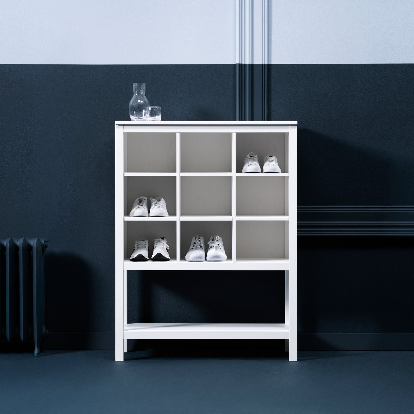  Un mobile contenitore HEMNES bianco con diverse scarpe inserite negli scomparti.