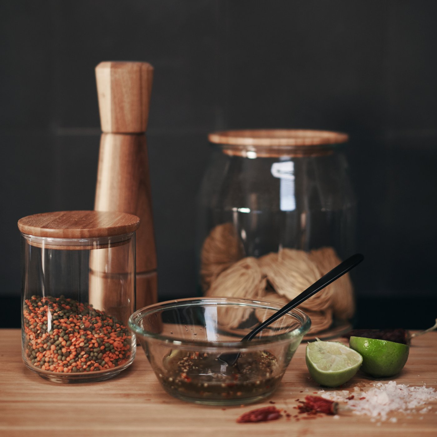 IKEA 365+ jars with lids in bamboo and of various sizes, with different contents standing on a wooden surface.