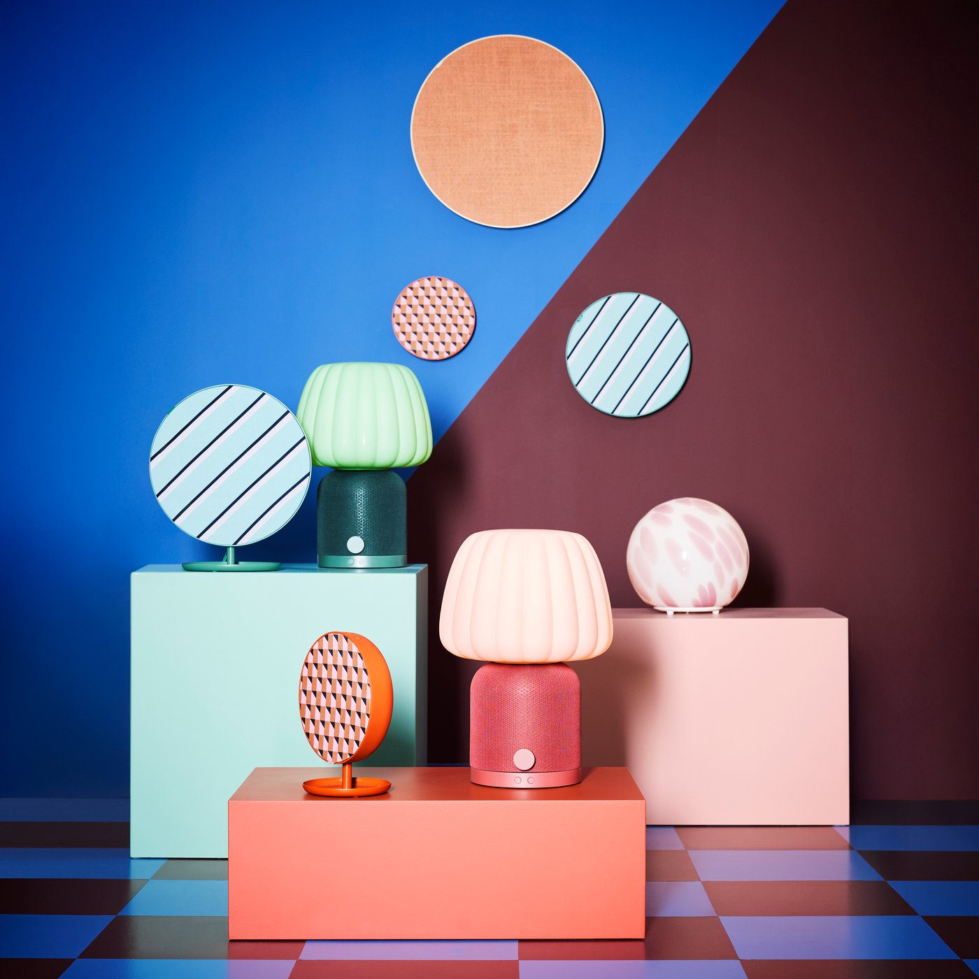 Et sjovt piedestalarrangement bestående af KULGLASS og SOLSKYDD Bluetooth-højttalerlamper og -højttalere sammen med en FADO lampe.