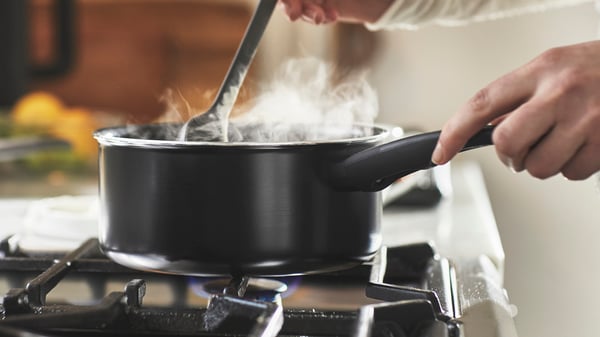 Une casserole HEMLAGAD noire à revêtement antiadhésif avec couvercle