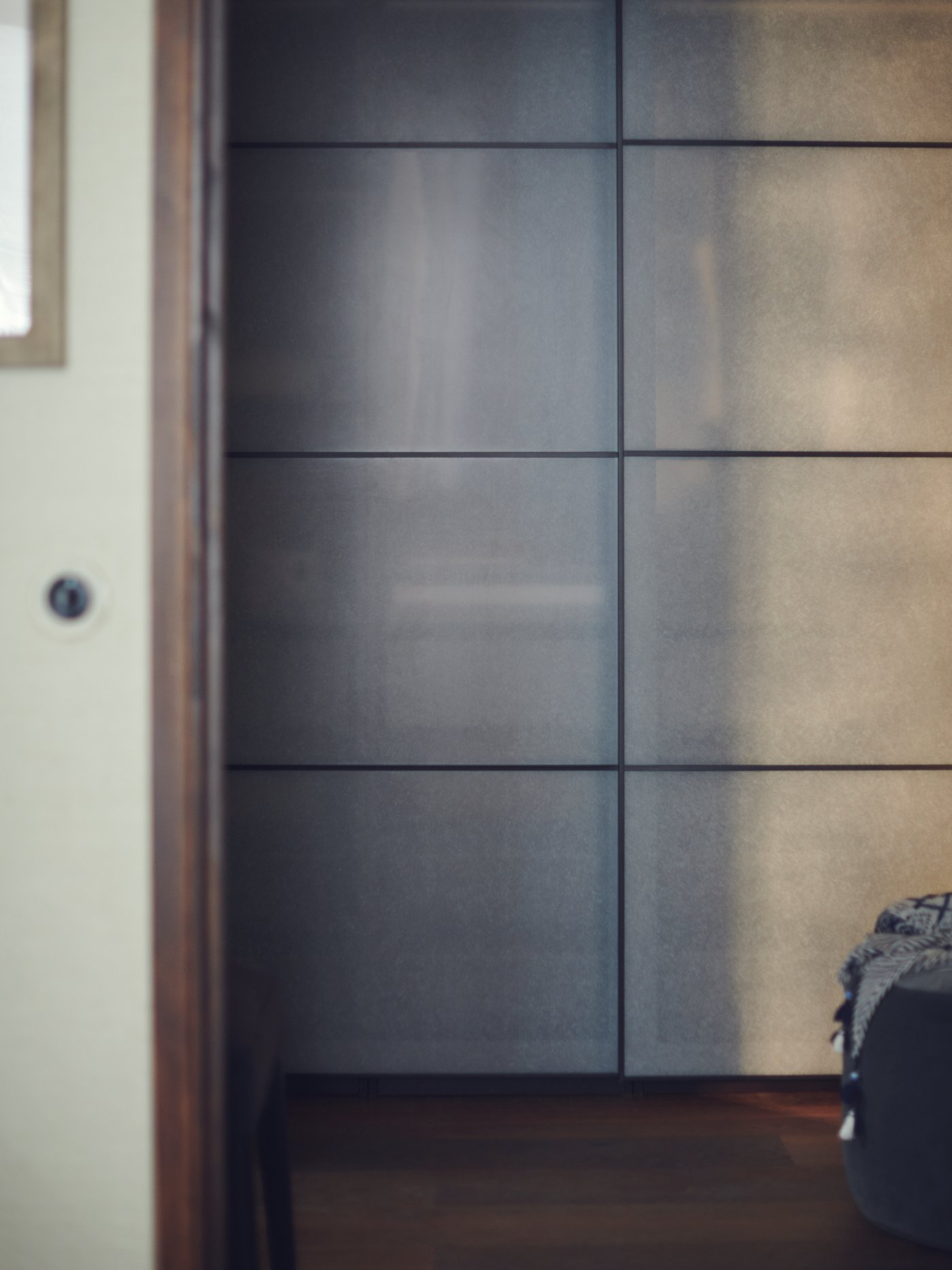 زوج من أبواب منزلقة مصنوعة من تأثير الورق فوق خزانة ملابس PAX على حائط باللون الأخضر الفاتح.