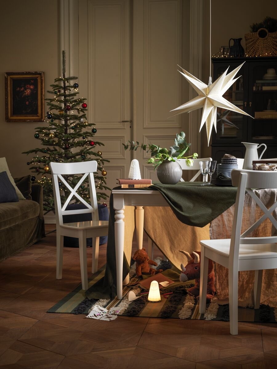 Albero di Natale e tavolo da pranzo in un soggiorno decorato per le feste; sotto il tavolo, un nascondiglio segreto pieno di giocattoli - IKEA