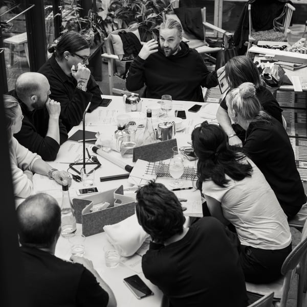 A group of people are seated around a large table having a meeting.