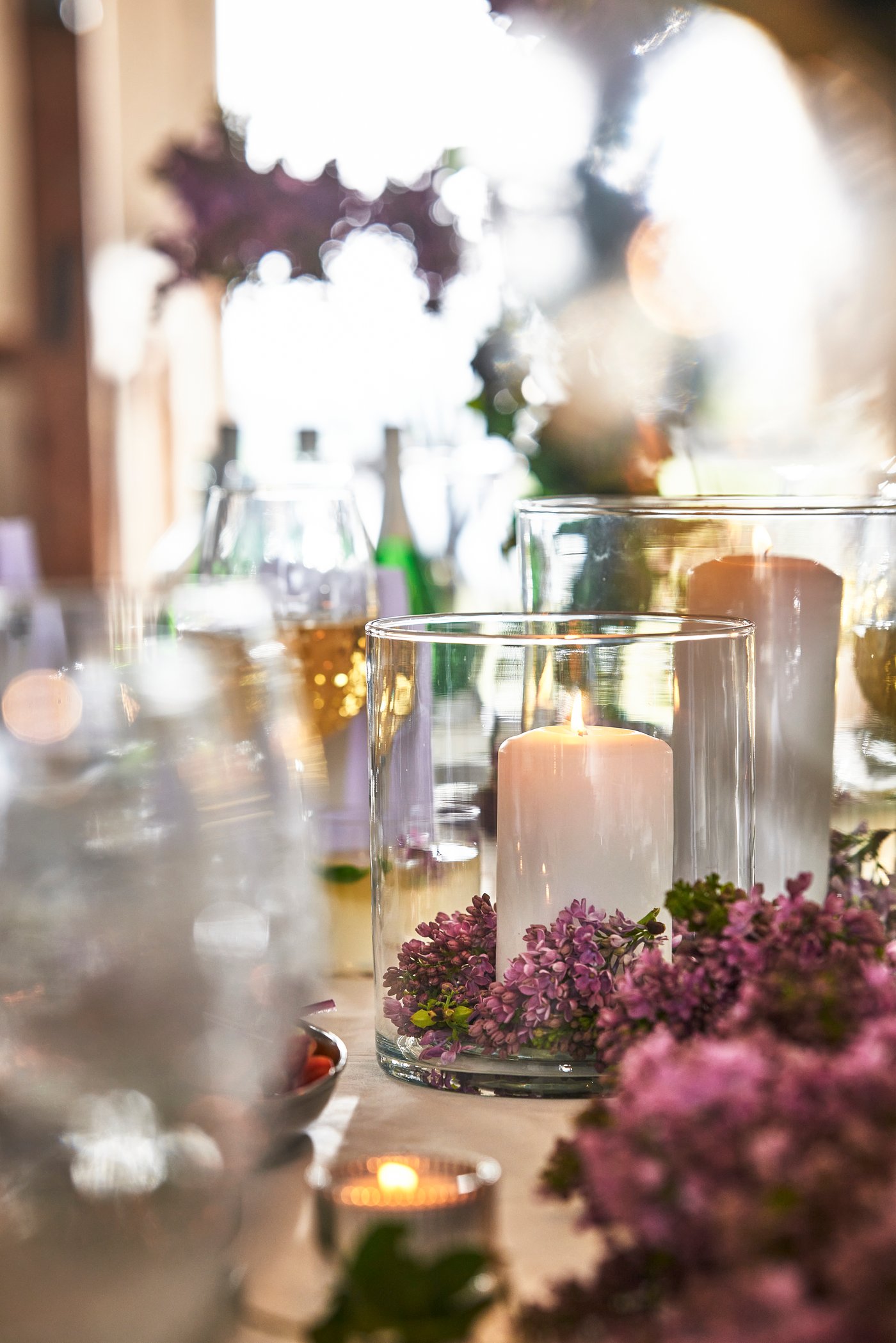 Ett blockljus i en ljushållare på en vit duk.