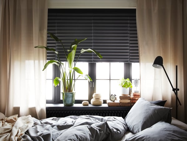 A black SKURUP floor/reading lamp in the bedroom