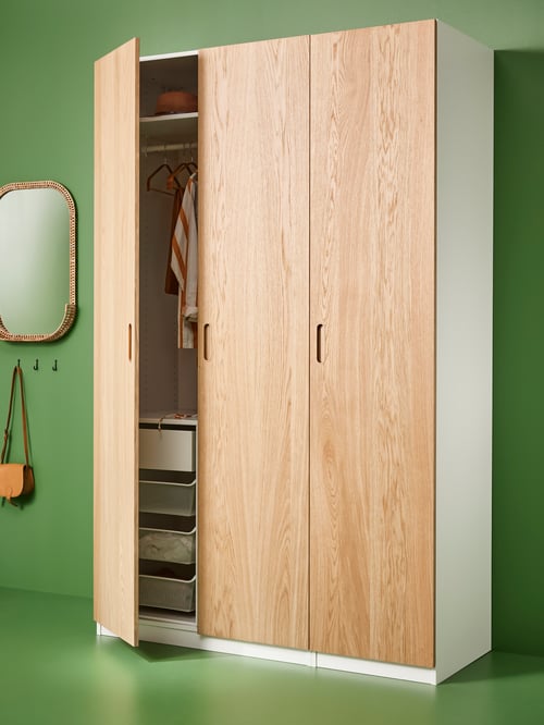 Hallway featuring a beige PAX wardrobe combination placed next to an oval SOMMARBO mirror and 2 HÖGAFFEL wall hooks.