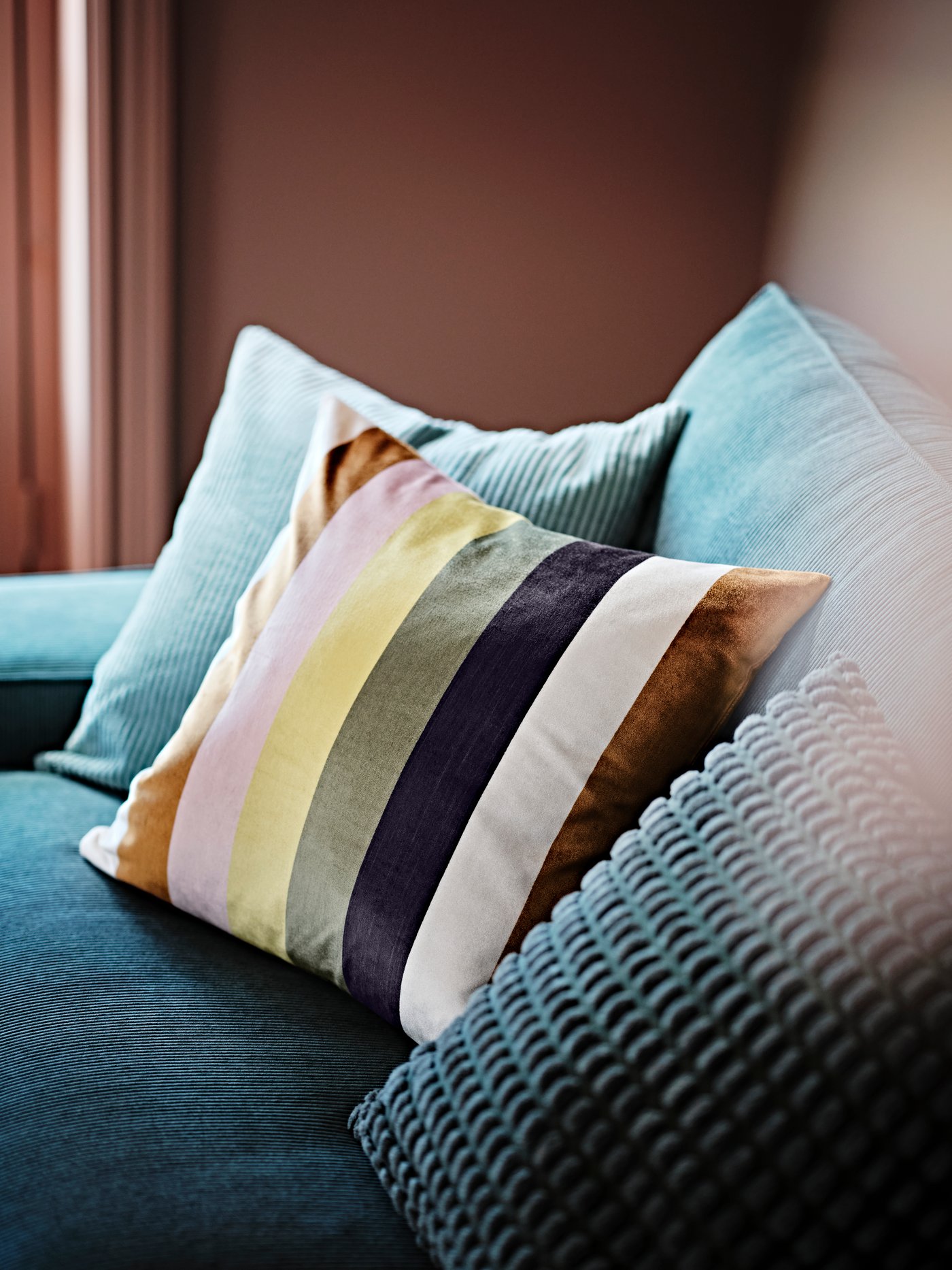 Noen puter er plassert på en fløyelssofa.