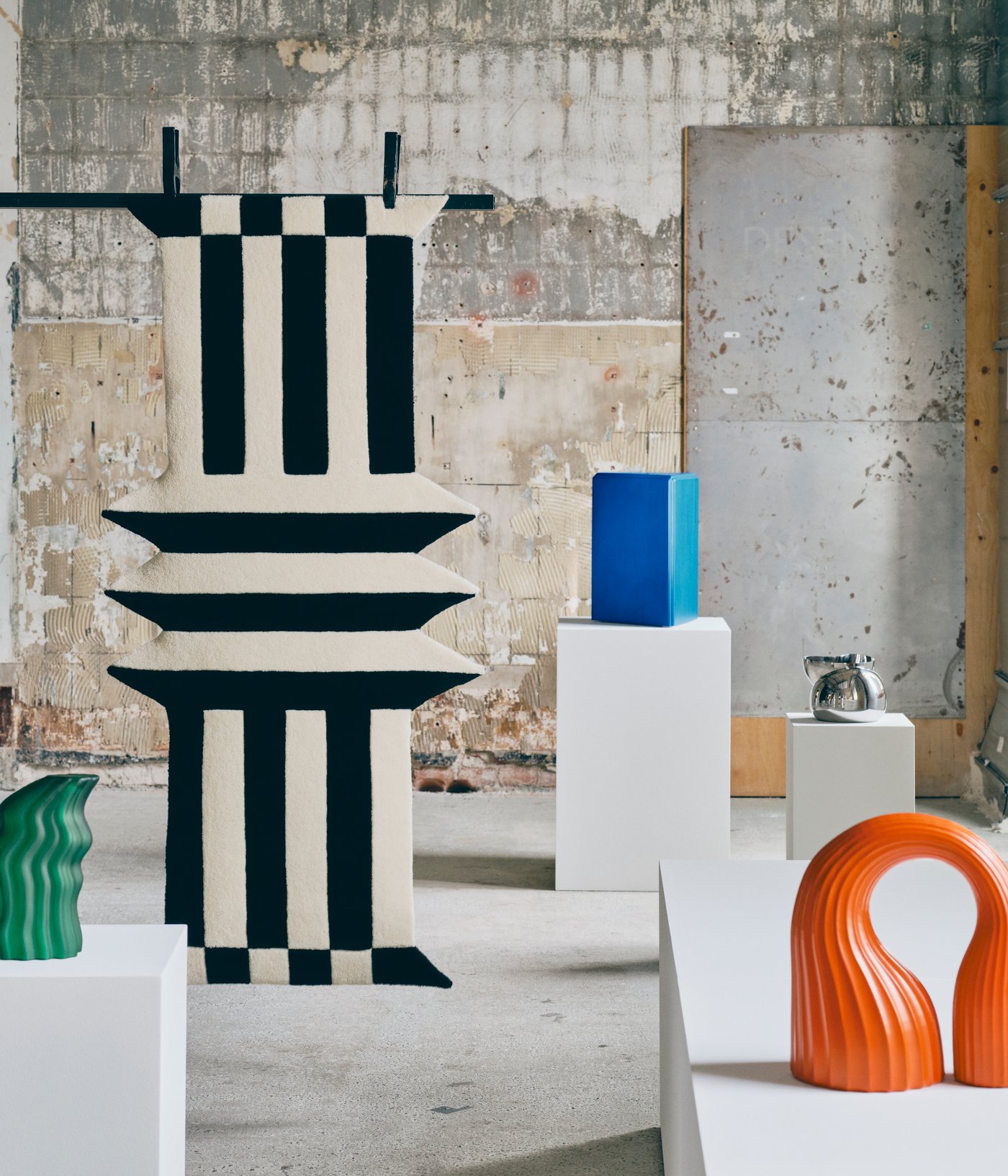 Ein Raum im Galeriestil, in dem fünf Kunstobjekte aus der IKEA KONSTRUNDA Kollektion auf weißen Sockeln stehen.