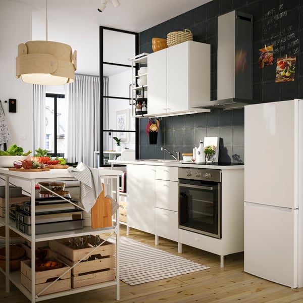 Cocina con muebles blancos y una isla de madera.