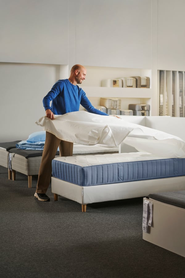 Un homme dans un magasin IKEA préparant un lit