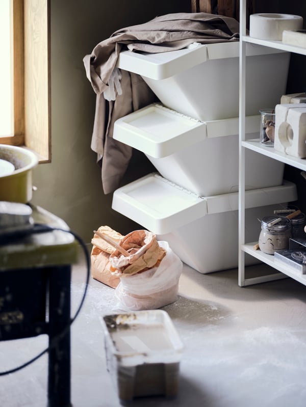 Un contenitore per la raccolta differenziata SORTERA bianco con coperchio nell'ufficio di casa